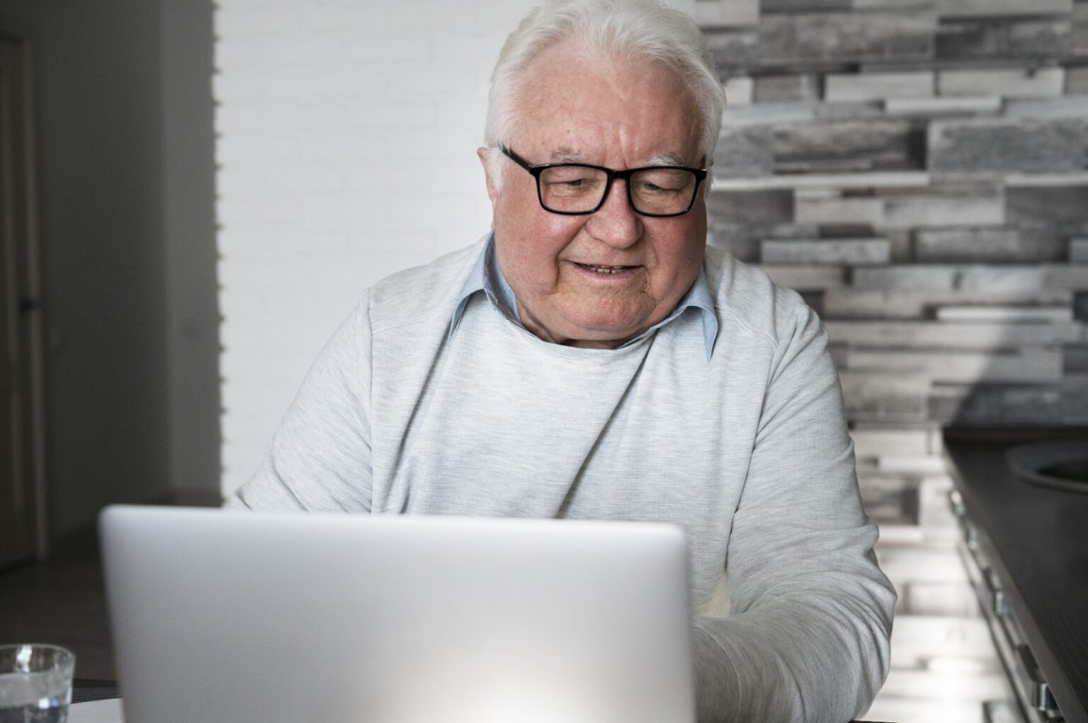 Aelterer Mensch laesst sich am Computer eine Webseite laut vorlesen