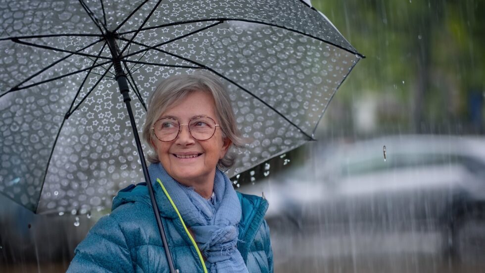 Seniorin mit grossem Regenschirm