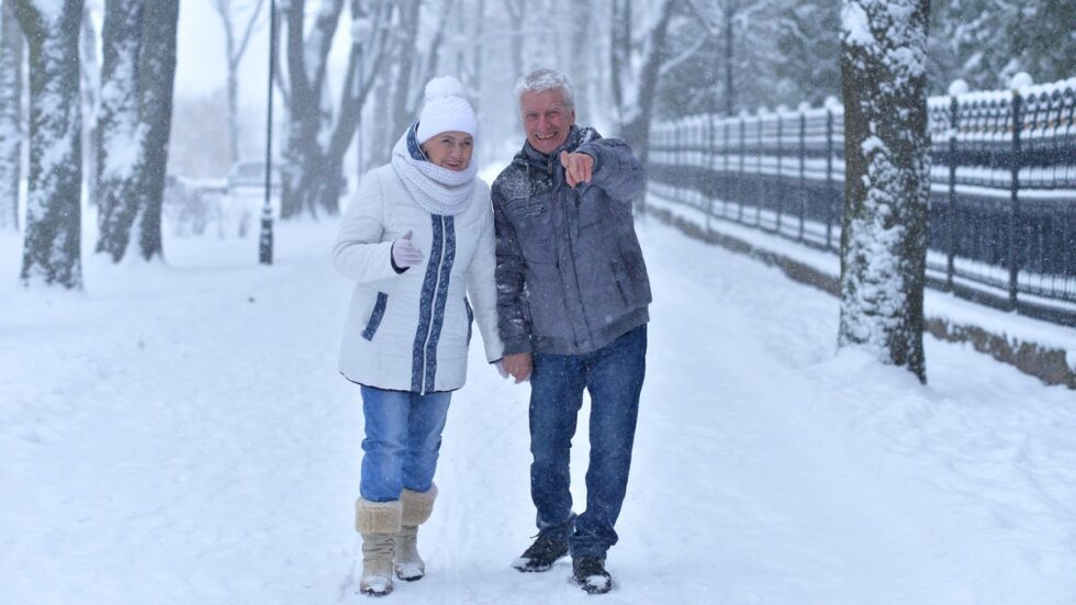 Aelteres Paar in Winterjacken beim Spaziergang